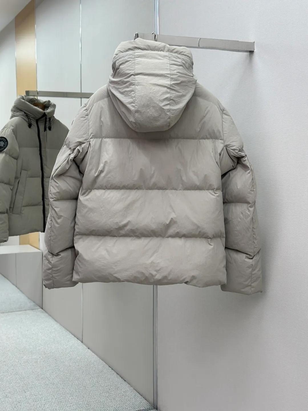 P1010 Canada Goose Black Label Badge Hooded Down Jacket (khaki) The high-quality filling is made of 90 national standard high-quality white duck down, selected high-loft velvet, weighing 240g, light and warm, with excellent temperature locking performance and good resilience. The fabric is woven with 400T high-count yarn. After special water-repellent treatment, the surface forms a lotus leaf effect - raindrops will slide down like beads, and snow particles will fall off when touched. The tear resistance reaches 200N (approximately 20kg load-bearing), the light gray matte texture breaks the stereotype of "outdoor clothing = hardcore", and the soft luster presents a high-end matte effect under urban neon lights, seamlessly switching scenes from ski resorts to CBD office buildings. The ribbon is woven with polyester as the base, and the brand letters are decorated on the ribbon through high-precision computer embroidery. The edges of the pattern are clear, the stitches are fine and even, and multiple layers of embroidery thread are stacked to enhance the three-dimensional effect. Precision thread reinforcement prevents linting and ensures the fluffy and resilient elasticity lasts as new. The embedded cuffs are three-dimensionally woven to form a "wavy" elastic structure, which forms natural folds when fitting the wrist, increasing the contact area with the skin, thus improving the windproof effect. At the same time, micro-velvet treatment is added to the inside of the cuffs, which feels like a second layer of skin and avoids friction on the skin from metal zippers or hard fabrics. Size:S-M-L-XL